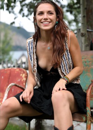 Милая девушка-подросток позирует не обнаженной на своей кровати во всем черном наряде